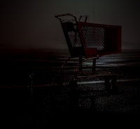 a shopping cart in a parking lot at night